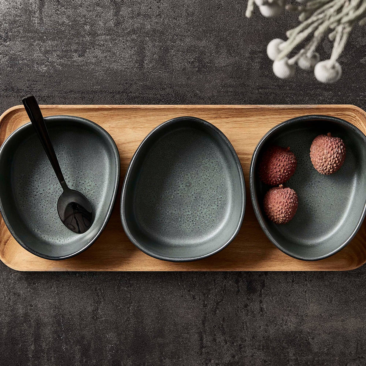 set of northern green RAW organic bowls by aida on a wooden serving tray
