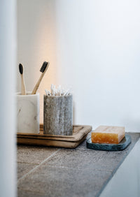 marble bathroom jar in beige used for cotton buds on a wooden tray
