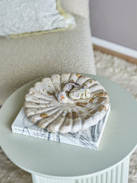 Round marble tray styled on coffee table with seashells and neutral decor