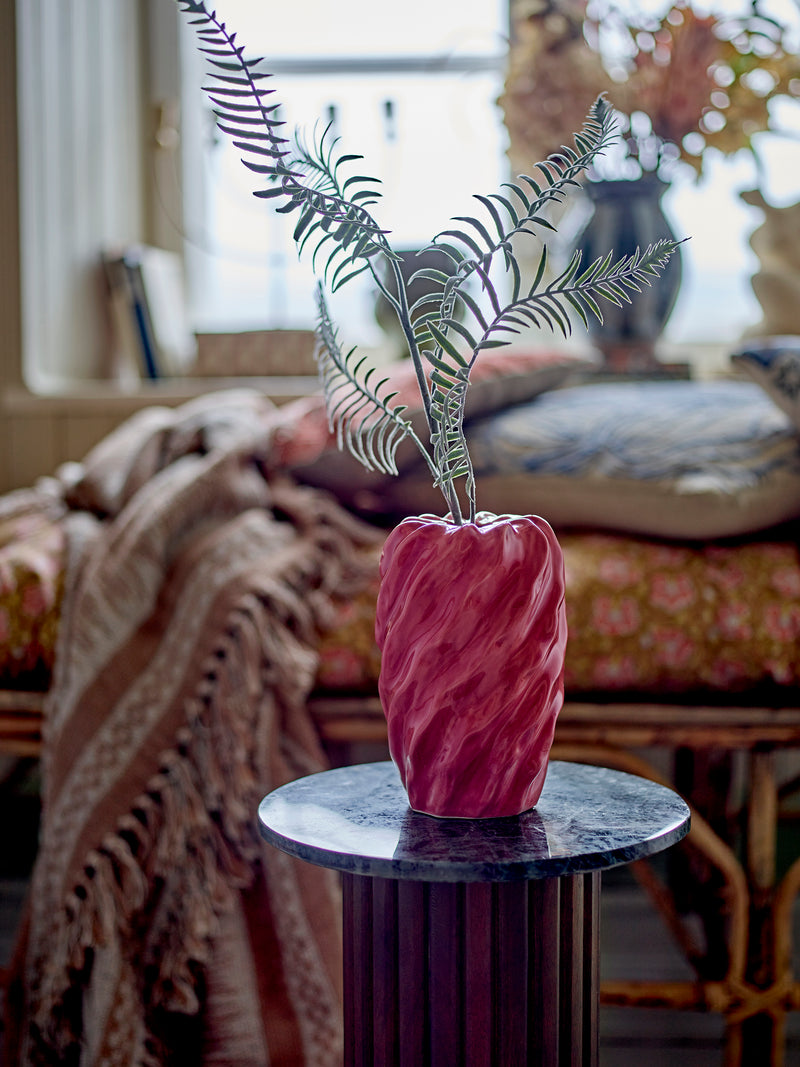 Rose stoneware vase displayed with fern stems in a cosy living space with soft furnishings