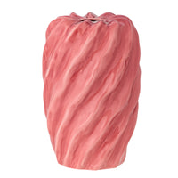 Close-up of pink twisted ceramic vase showing wavy surface and glossy glaze