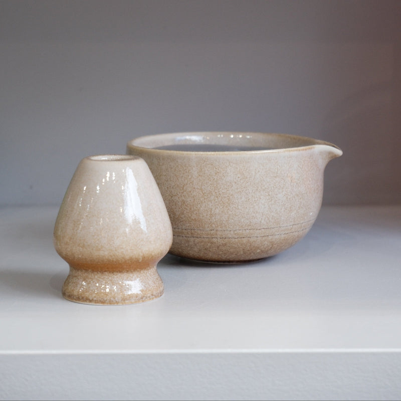 sand coloured ceramic matcha bowl with pouring spout and matching whisk stand
