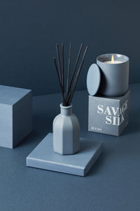 Savage Silk ceramic candle with matching box and reed diffuser in deep blue tones
