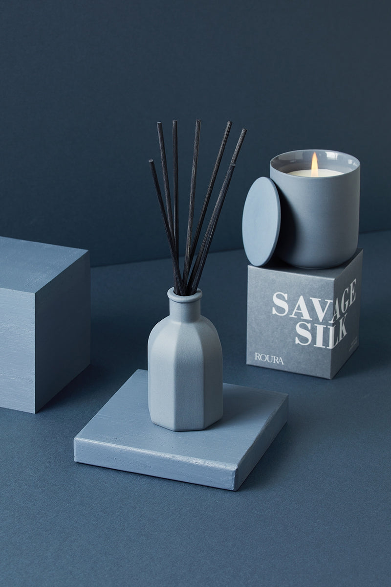 Savage Silk ceramic candle with matching box and reed diffuser in deep blue tones
