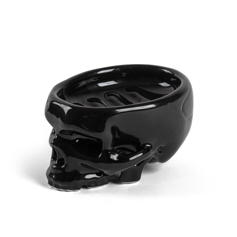 Side profile of glossy black skull soap tray showing drainage ridges
