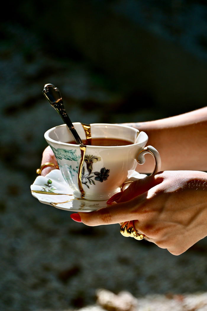 tea served in Seletti Kintsugi cup with gold seams held in hand for a modern tea ritual
