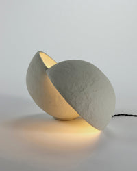 Serax Earth paper mâché table lamp lit, showing the opening between the two halves