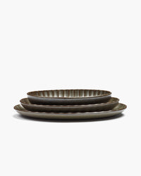 Stacked green Inku oval serving bowls by Serax