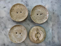 four ceramic soap dishes showing the makers mark and handmade details