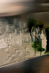 Skye wine glasses by Olsson & Jensen lined up on a mirrored shelf