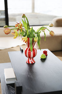 Coffee table styled with a vase of flowers and colourful candle holders