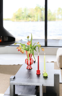 Coffee table in a bright living room styled with flowers and colourful candle holders