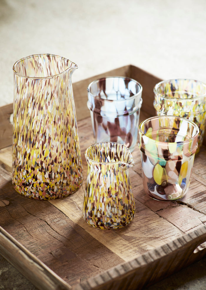 colourful glass milk jug styled on wooden tray with matching tumblers
