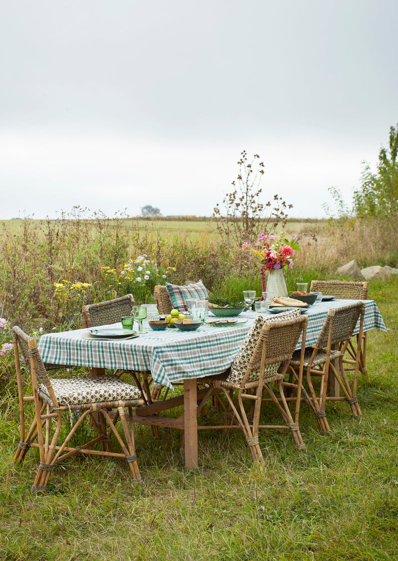 outdoor summer table with dotted glass jug and green glass tumblers
