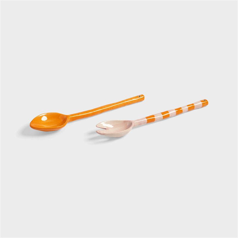 Striped porcelain salad servers adding colour to an outdoor table setting.