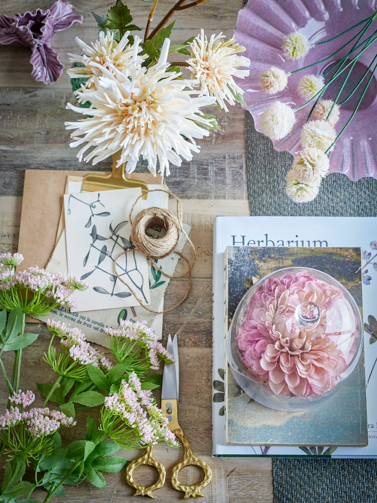 Top-down styling view with phlox stems and faux blooms on wooden table