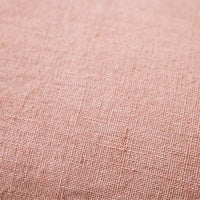 Close-up of woven linen texture on dusty peach cushion