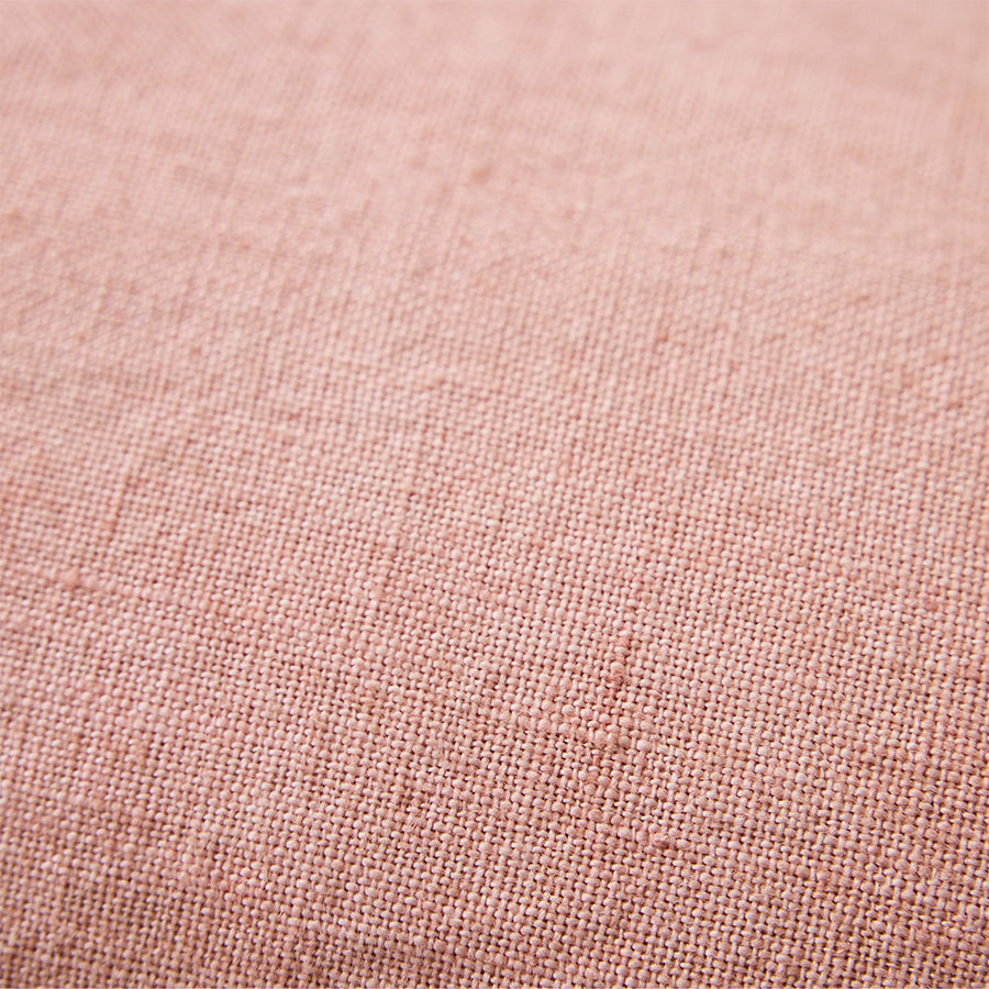 Close-up of woven linen texture on dusty peach cushion