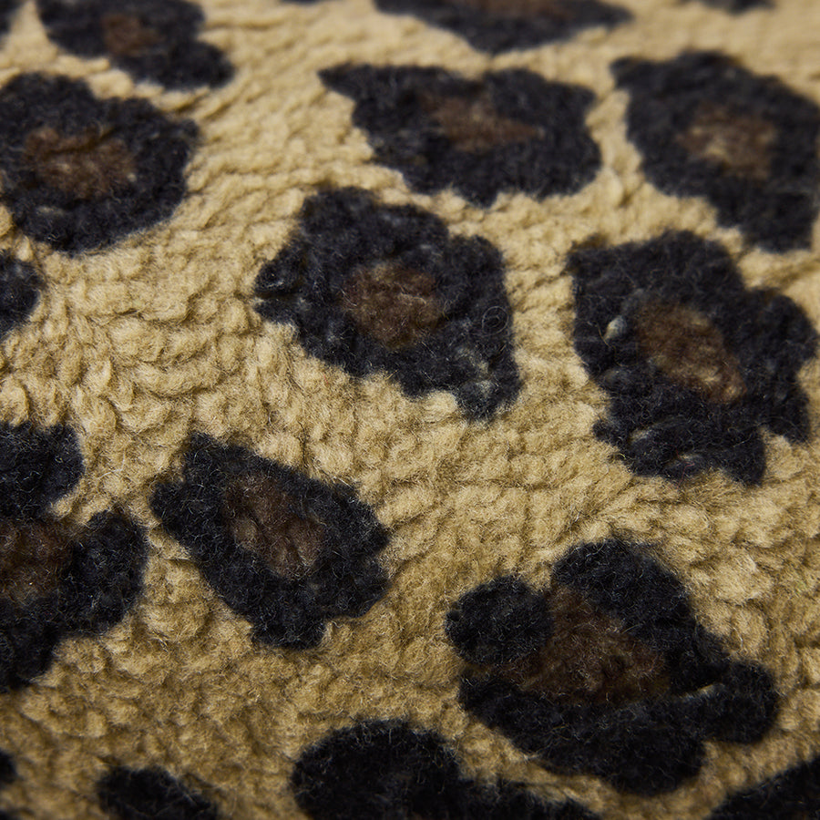 Close-up macro view of the HKLIVING Panther bolster cushion's fabric, showing the brushed leopard print texture in caramel and black