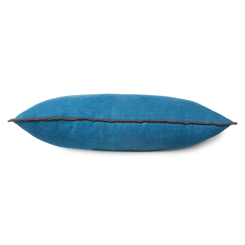 side view of a plump cushion in blue with brown pipping around its edge