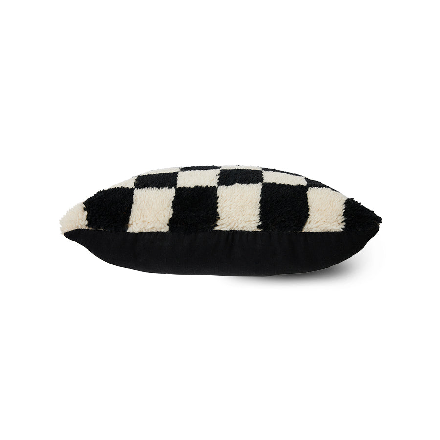 side view of checkered black and white fluffy cushion on the top and black underside