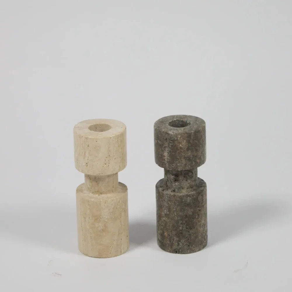 Light and dark asymmetric travertine candle holders by Olsson & Jensen side by side