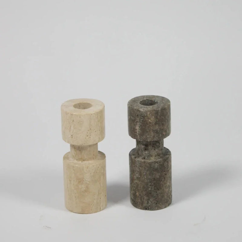 Light and dark asymmetric travertine candle holders by Olsson & Jensen side by side