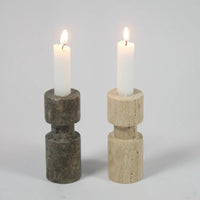 Dark and light asymmetric travertine candle holders by Olsson & Jensen with lit candles