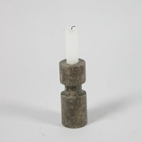 Dark travertine asymmetric candle holder by Olsson & Jensen with a white candle