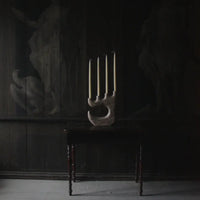 Travis four-arm candle holder by Olsson & Jensen with tall candles in a dark room