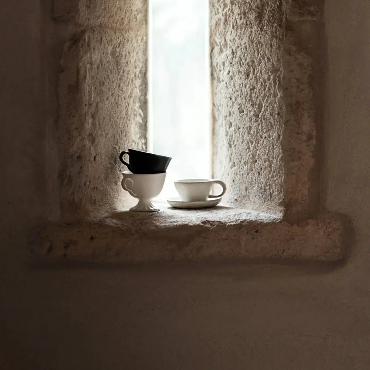 Tuva cup and saucer by Olsson & Jensen styled in a stone window
