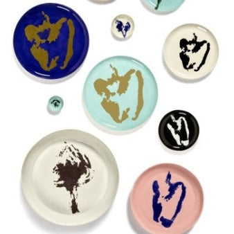 an image of a range of different serving plates and platters for feasts and dinner parties or just a meal with your family in blues, pinks, black, off white, and gold in ottolenghi style and serax quality