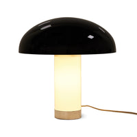 switched on now, the monochrome mushroom lamp stands tall with the white base now glowing a glorious cream colour and it's black shade unaffected and still reflecting the people and items around it. The chrome coloar at the bottom of its base showing the hk liviing logo