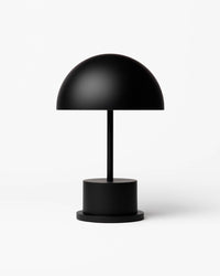 matte black portable Riviera lamp with dome shade and cylindrical base
