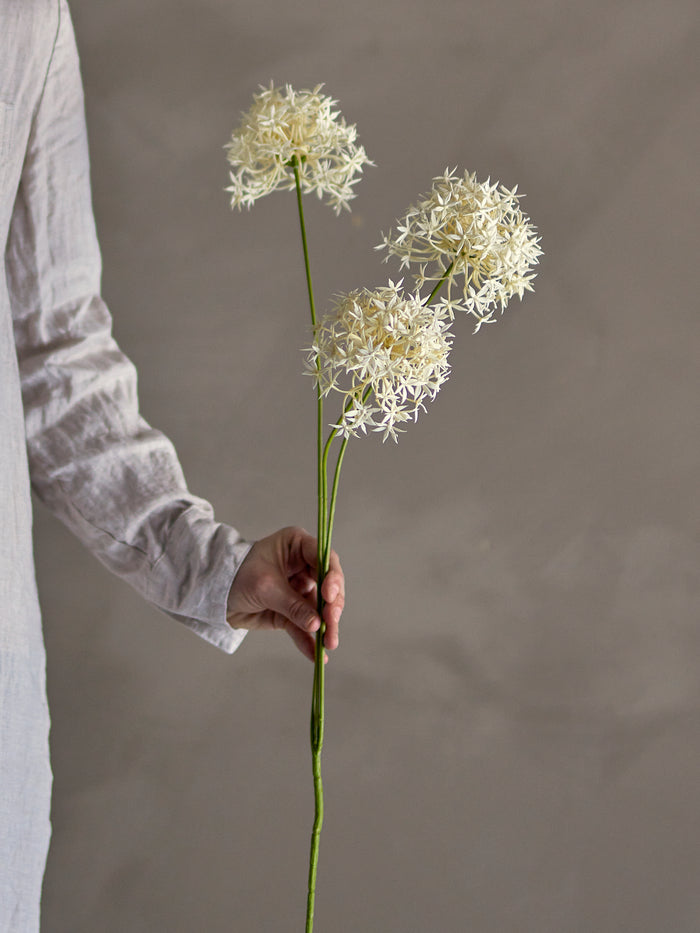 Faux allium flower stem held in hand
