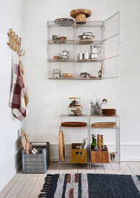 paulownia wood boards and trays styled on open metal kitchen shelving in nordic home