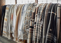 Hanging display of assorted woven throws in neutral and warm designs