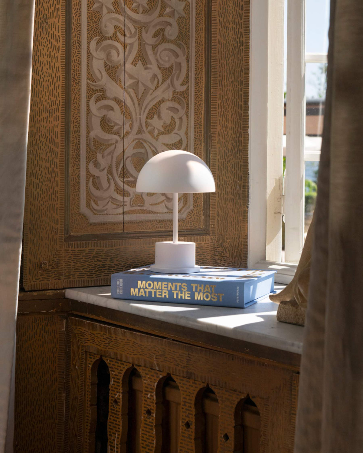 white portable LED lamp placed on a windowsill for cosy glow
