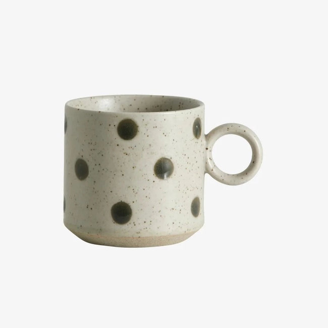 grainy dotted light green cup with a round handle and spots of darker green