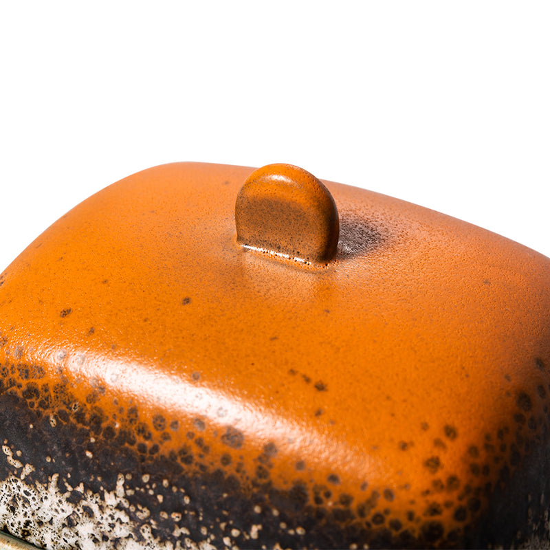 close up of the orange and brown lid and the button handle of the meteor butter dish