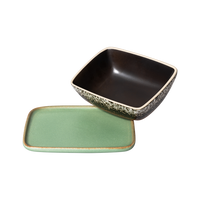 the metoer butter dish from hk living showing the green base plate and an upturned top lid showing the dark brown colour inside