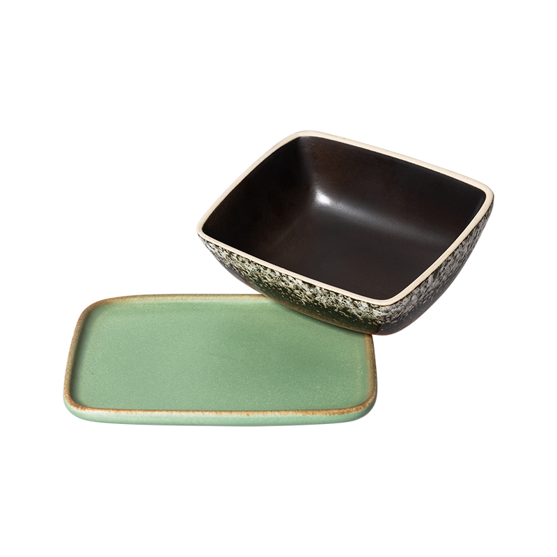 the metoer butter dish from hk living showing the green base plate and an upturned top lid showing the dark brown colour inside