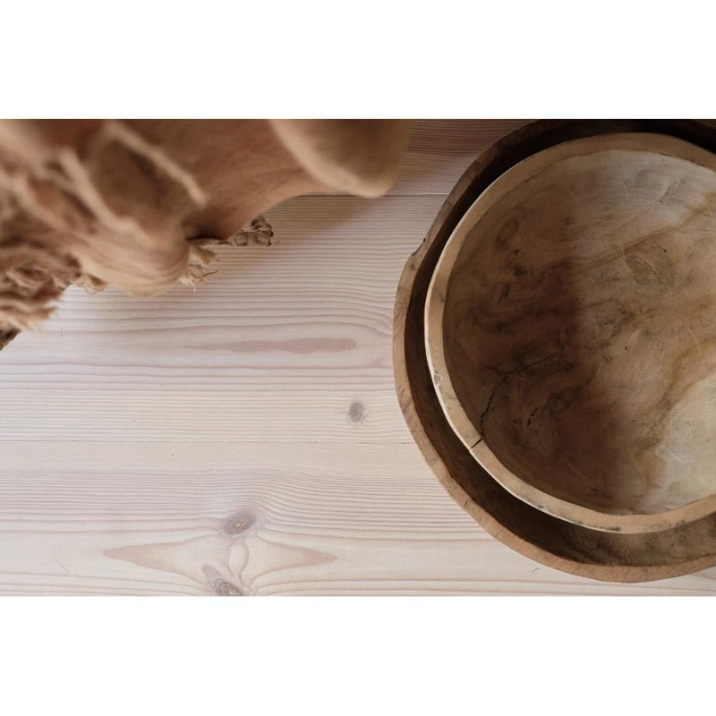 close up image of wooden bowls from above sitting on a wooden floor