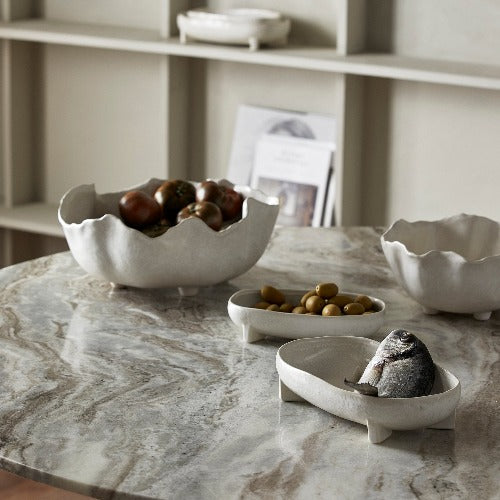 selection of whhite decorative bowls on a grey marble table