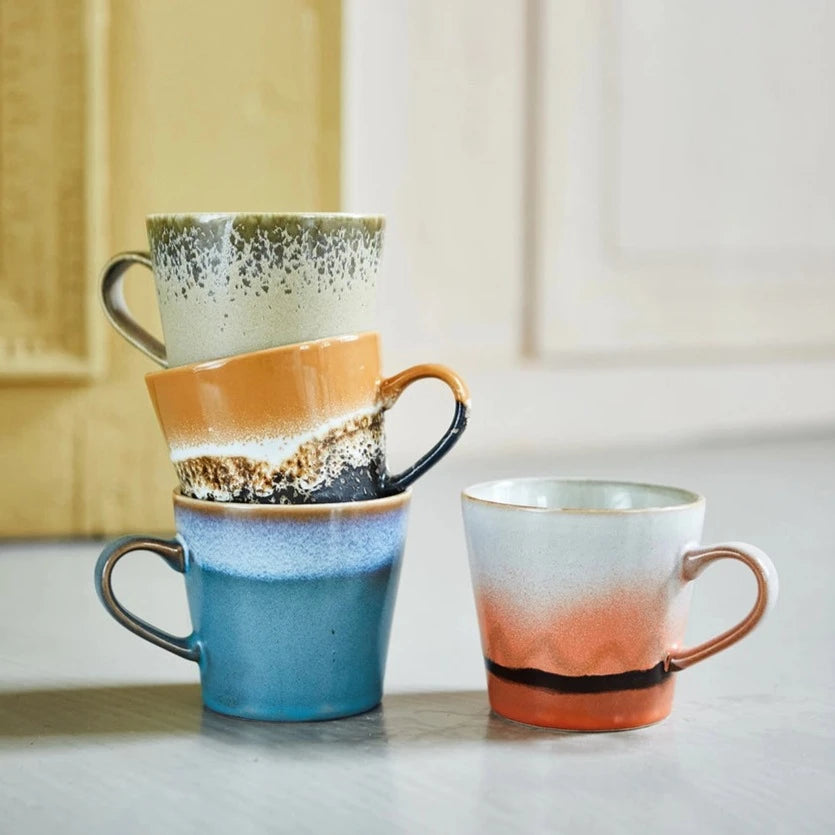 4 handled americano mugs inclding a blue one, a reddish orange and beige one, and brown and black one, and a green one, all from hk livings 70s collection