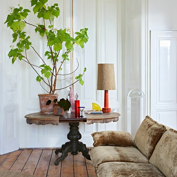 red lava table lamp with a boucle brown lanmp shade sits apon an antique table in hkliving design